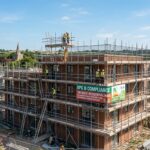 Large building with scaffolding and signage for EPC B Compliance